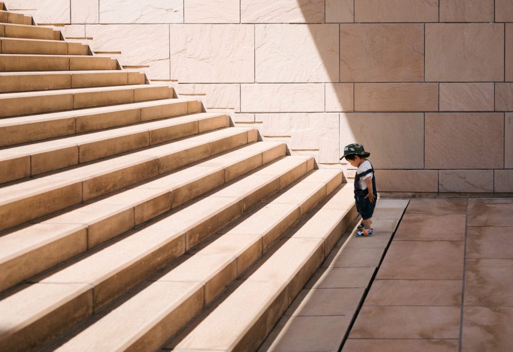 child contemplates a staircase